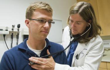 A doctor examines a patient with a stethoscope