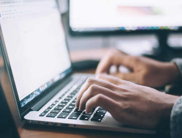 hands typing on a laptop
